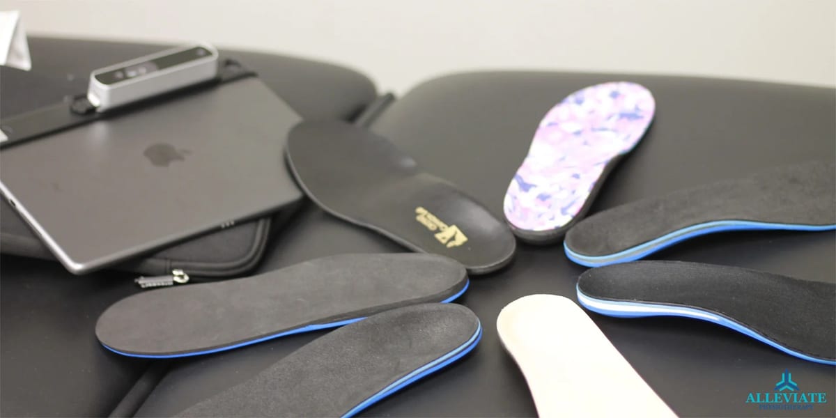 A ring of custom orthotic insoles laid out beside a scanner
